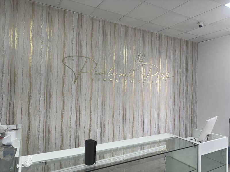 An image of gold interior signage and wall decor for a business.